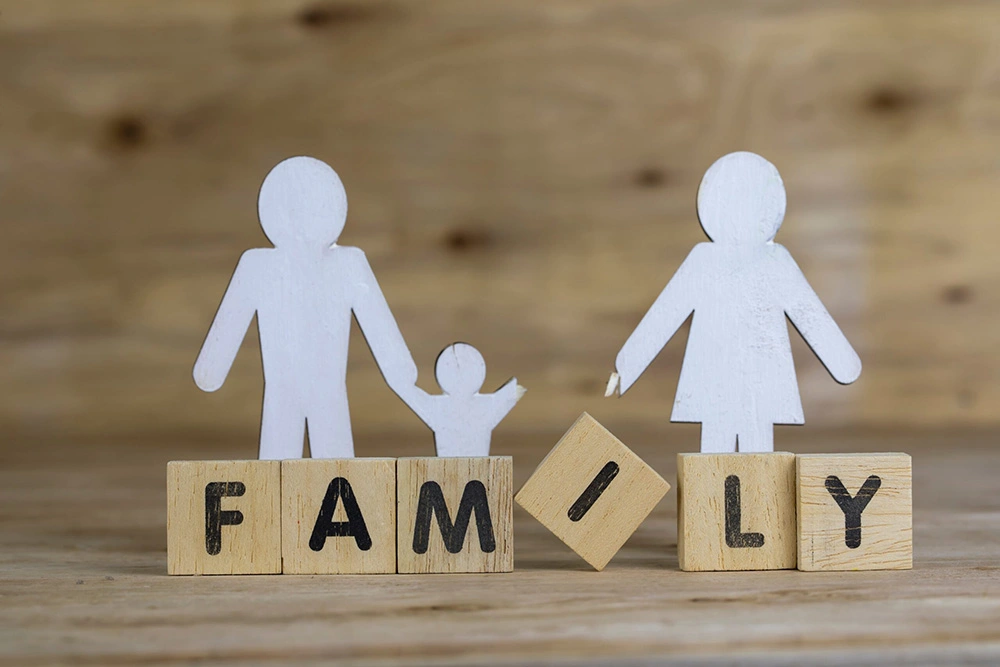 Stick figure of family holding hands is broken between one of the child’s hands and parent. Our Sugar Land child custody lawyers will help resolve legal agreements on a child’s custody.